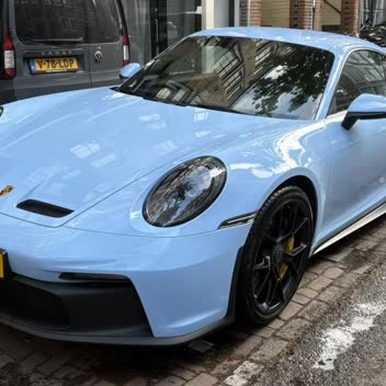 A blue Porsche 911 GT3 detailed on an Amsterdam street.